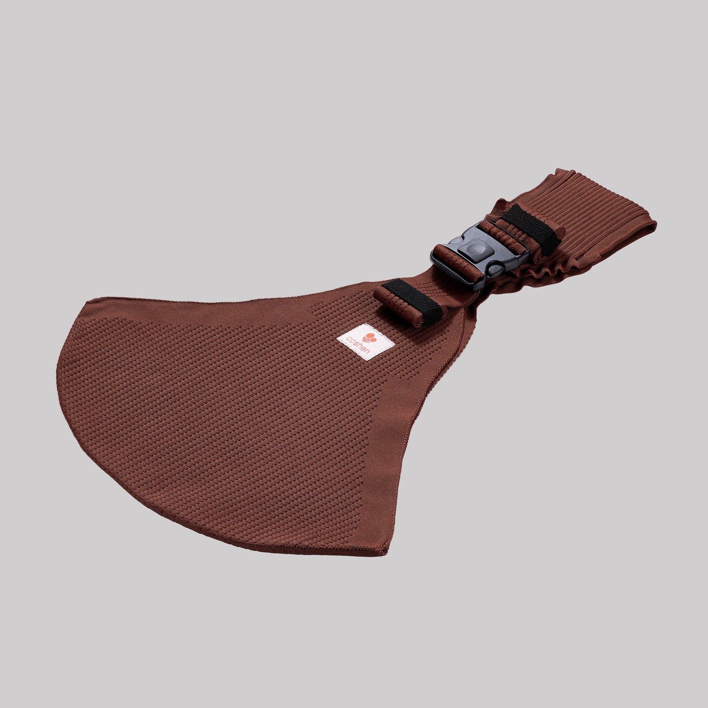 Angled perspective view of the mocha brown Coshen carrier, highlighting the breathable 3D knit textile and contoured shoulder strap for maximum parent comfort.