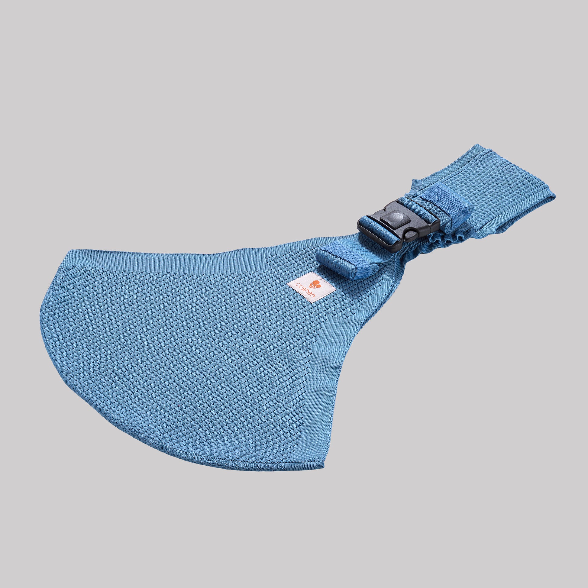 Angled perspective view of the coral blue Coshen carrier, highlighting the breathable 3D knit textile and minimalist design for active parents.
