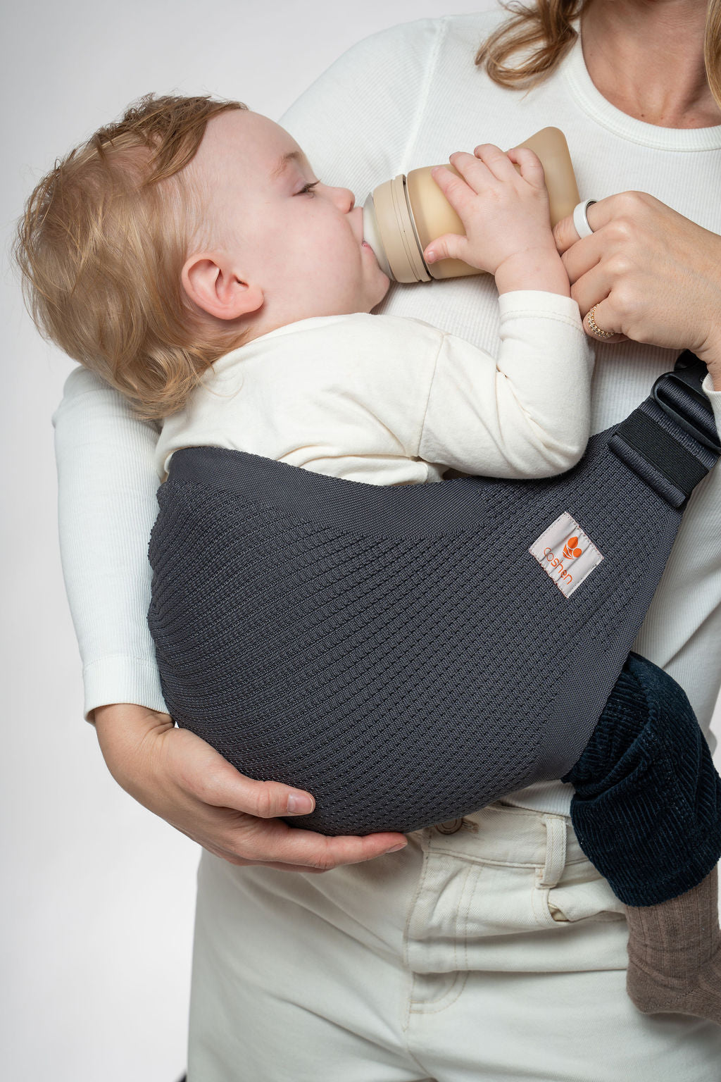 Coshen Icon seamless knit toddler hip carrier in anthracite gray supporting baby's natural C-curve and M-position.
