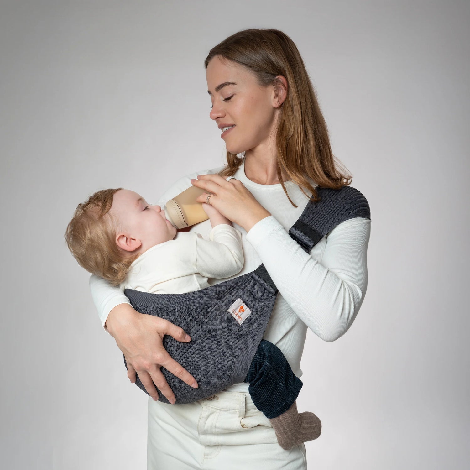 Maman utilisant le porte-bébé Coshen en tricot 3D sans couture, démontrant la position ergonomique en M pour le développement des hanches.